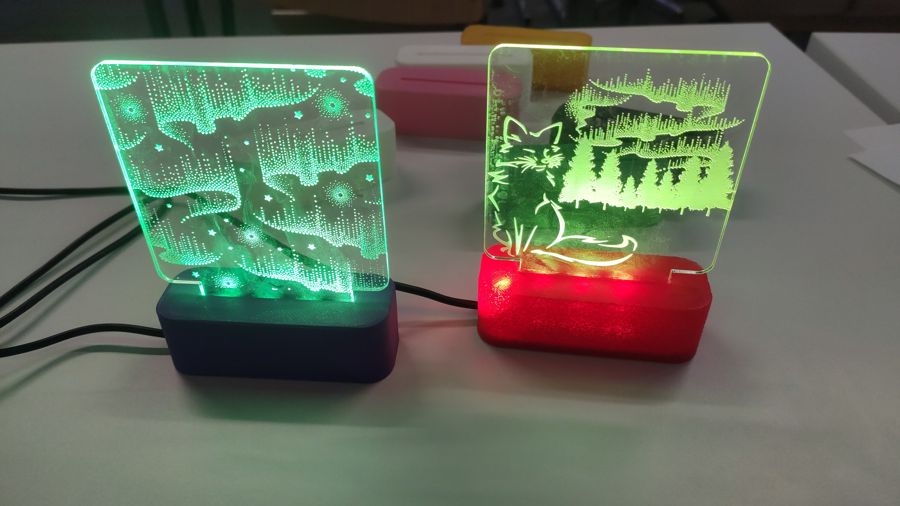 Two Aurora Lamps with laser-engraved acrylic panels glowing green on 3D-printed bases